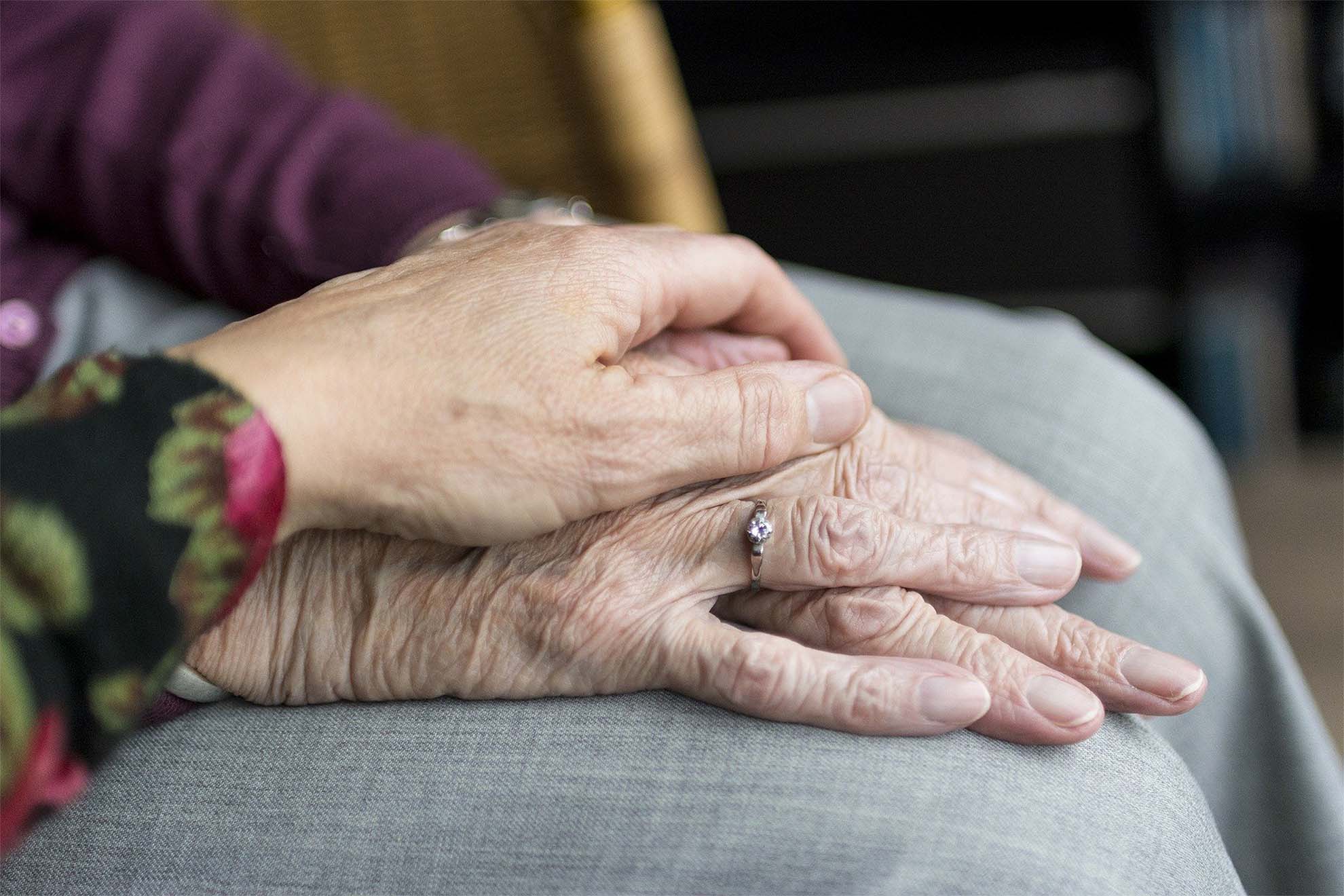 Closeup of two people holding hands.