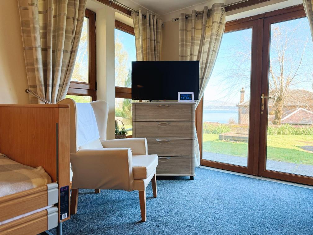 Airy room with a big window and TV on a table.