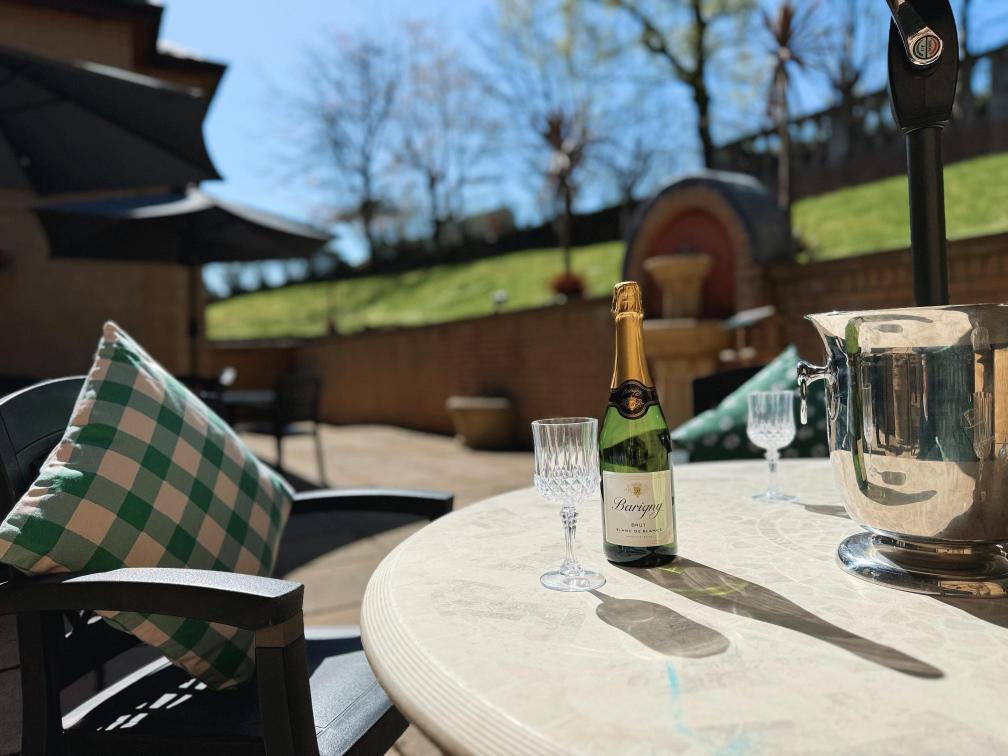 Champagne and glass on a sunny table.