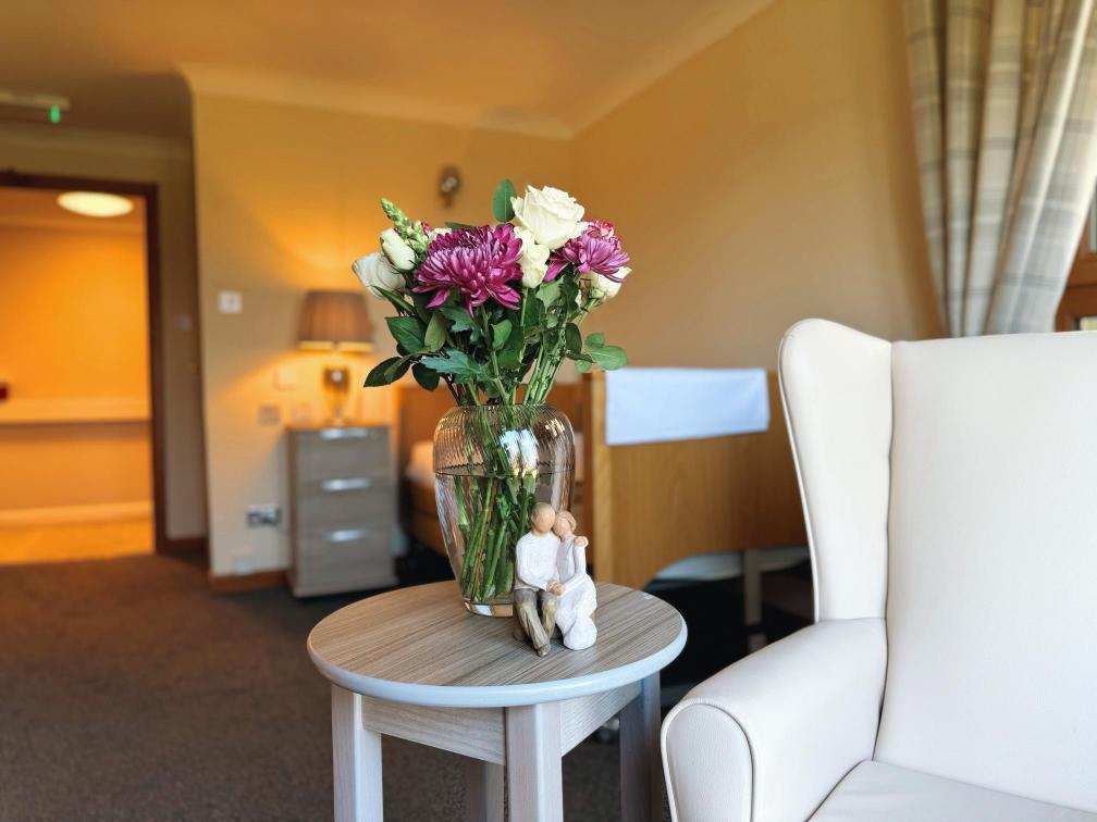 Selection of red and white flowers next to an armchair.