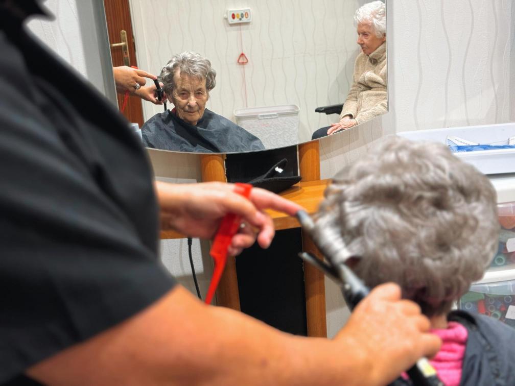 Resident getting their hair curled at a salon.