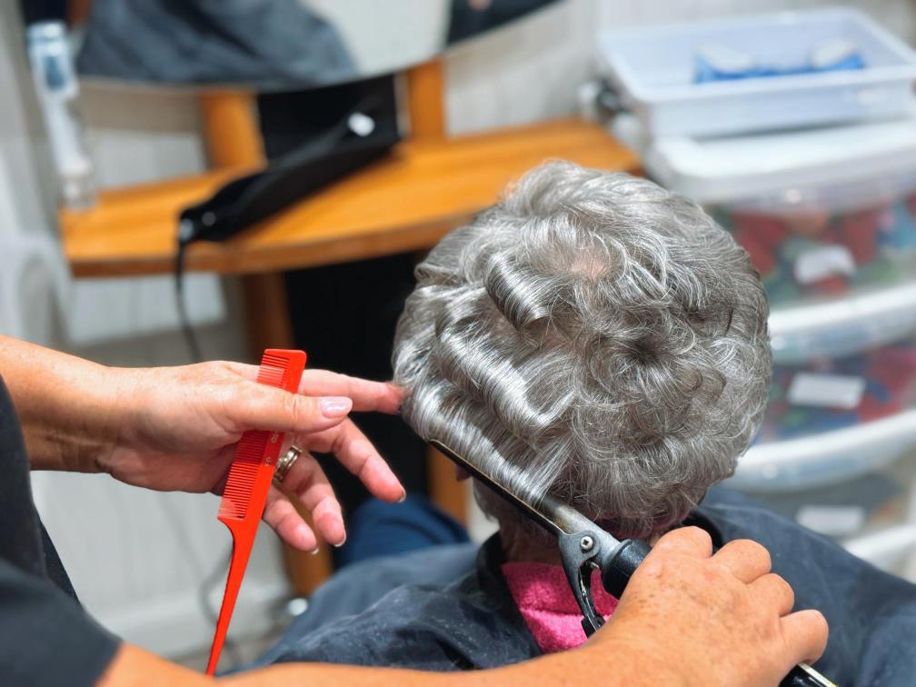 Lady having her hair curled at the salon.