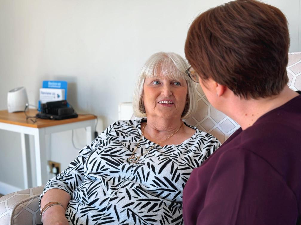 Care home resident having a conversation with someone.